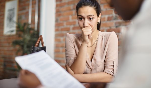 Worried woman thinking of something while having job interview at corporate office.