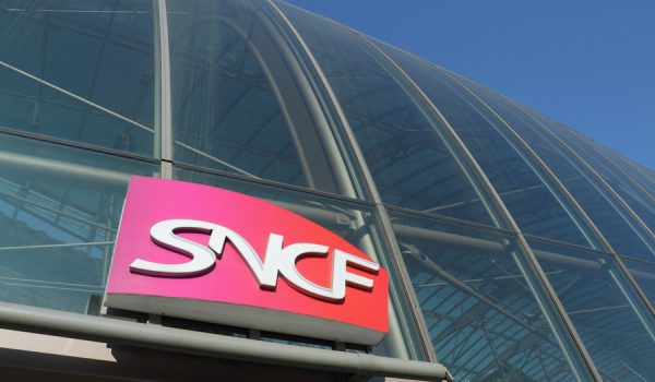 Strasbourg, France - February 5, 2012: The sign of the SNCF, Societe Nationale des Chemins de fer Francais ( National corporation of French Railways ) on the glas dome at the front side of the Strasbourg central station. View from the sidewalk in front of the entrance. Strasbourg, Alsace, France.