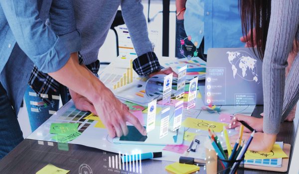 Close up ux developer and ui designer use augmented reality app brainstorming about mobile interface wireframe design on desk at modern office.Creative digital development agency