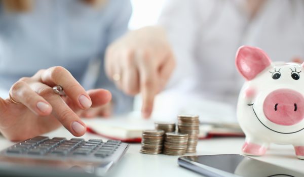 Man and woman hand consider on calculator expenses of family budget aganist home background. Lending purchase rental housing mortgage concept