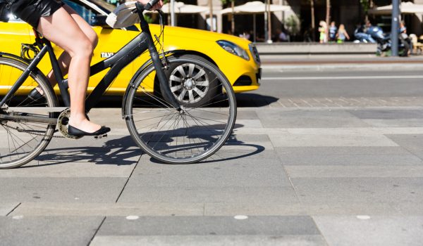 Unidentifiable female person riding a bicycle in the city centre.