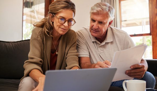 Retirement couple budget, finance and investment planning, loan and paper bills with laptop technology in home. Mature people money, cash savings or legal insurance document report on online bank